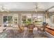 Enclosed sunroom with ceiling fans and three rocking chairs overlooking the yard at 8961 Se 130Th Loop, Summerfield, FL 34491