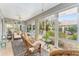 Enclosed sunroom features ceiling fan, tile flooring, and three rocking chairs at 8961 Se 130Th Loop, Summerfield, FL 34491