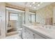 Bathroom with a double sink vanity, enclosed shower with glass door, neutral colored walls, and tile floor at 9305 Bahia Track Way, Ocala, FL 34472