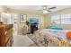 Bright bedroom with ceiling fan, large window, and attached bathroom at 9305 Bahia Track Way, Ocala, FL 34472