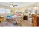 Bright bedroom with a ceiling fan, lamps, and colorful decor at 9305 Bahia Track Way, Ocala, FL 34472