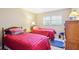 Bedroom featuring two twin beds and a window with natural light at 9305 Bahia Track Way, Ocala, FL 34472