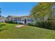 Charming single story home with a well-manicured lawn, mature landscaping, and a sidewalk leading to the front door at 9305 Bahia Track Way, Ocala, FL 34472