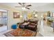 Cozy living room with a plush leather couch, ceiling fans, and an eye-catching oriental rug at 9305 Bahia Track Way, Ocala, FL 34472