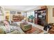 Bright living room featuring a large sectional sofa, bookshelves, and a comfortable workspace at 9305 Bahia Track Way, Ocala, FL 34472