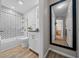 Stylish bathroom with shower-tub, white vanity, large mirror, and tile accents at 9463 Sw 93Rd Loop, Ocala, FL 34481