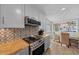 Bright kitchen with white cabinets, butcher block countertops, and stainless steel appliances at 9463 Sw 93Rd Loop, Ocala, FL 34481