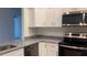 Well-equipped kitchen boasts stainless steel appliances, granite countertops, and sleek white cabinetry at Tbd Malauka Rd, Ocklawaha, FL 32179