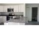 Stylish kitchen featuring stainless steel appliances, granite countertops, and white cabinetry at Tbd Malauka Rd, Ocklawaha, FL 32179