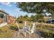 Landscaped backyard featuring a stone patio with a charming wrought-iron table and chairs for outdoor dining at 10071 Sw 90Th Loop, Ocala, FL 34481