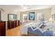 Bright bedroom features hardwood floors, a large dresser, and comfortable, decorated bed at 10071 Sw 90Th Loop, Ocala, FL 34481