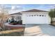 A view of the home and driveway, showing the two-car garage and well-kept lawn at 10071 Sw 90Th Loop, Ocala, FL 34481