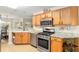 Well-equipped kitchen featuring stainless steel appliances, granite countertops, and natural wood cabinets at 10071 Sw 90Th Loop, Ocala, FL 34481