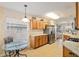 Open kitchen view showcases wooden cabinetry, a stainless steel refrigerator, and a breakfast nook at 10071 Sw 90Th Loop, Ocala, FL 34481