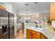 Open-concept kitchen featuring granite counters and stainless fridge at 10071 Sw 90Th Loop, Ocala, FL 34481