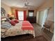 Bright bedroom with wood floors, ceiling fan, dresser, and comfortable bed with colorful pillows at 1118 Pelion Pl, The Villages, FL 32162