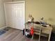 Bedroom featuring a closet with white doors, a desk, and chair on wood-look flooring at 1118 Pelion Pl, The Villages, FL 32162