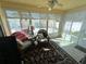 Bright sunroom with tile floor, ceiling fan, and large windows overlooking the private backyard at 1118 Pelion Pl, The Villages, FL 32162