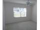 Bright bedroom featuring neutral walls, carpet, ceiling fan, and a window for natural light and neighborhood view at 11665 Sw 72Nd Cir, Ocala, FL 34476