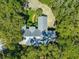 A high angle view of a home with a metal roof surrounded by trees and a circle driveway at 12336 E Highway 25, Ocklawaha, FL 32179
