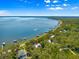 An aerial shot displays a lakefront home with private dock, close to the water and surrounded by trees at 12336 E Highway 25, Ocklawaha, FL 32179