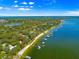 Aerial view of a home with a dock along the green waters with beautiful blue skies and a lake at 12336 E Highway 25, Ocklawaha, FL 32179