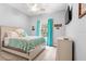 Cozy bedroom with queen bed, ceiling fan, and large window with blue curtains for natural light at 12336 E Highway 25, Ocklawaha, FL 32179
