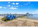 Wooden dock featuring blue chairs extending into the water, sunny day at 12336 E Highway 25, Ocklawaha, FL 32179