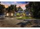 Beautiful home featuring stone accents, a metal roof, and mature palm trees at sunset at 12336 E Highway 25, Ocklawaha, FL 32179