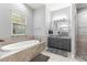 Bright main bathroom featuring a large soaking tub, vanity, and stand up shower at 12336 E Highway 25, Ocklawaha, FL 32179