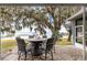 Covered patio features an outdoor dining set and a scenic lake view at 12336 E Highway 25, Ocklawaha, FL 32179