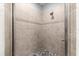 Close-up of a glass enclosed stand up shower featuring tiled walls and a pebble floor detail at 12336 E Highway 25, Ocklawaha, FL 32179