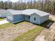 Light blue home with white trim, gray roof, and unfinished landscaping at 12876 Se 42Nd Ct, Belleview, FL 34420