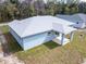 Light blue home's rear exterior with a covered patio and light gray roof at 12876 Se 42Nd Ct, Belleview, FL 34420
