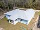 Rear exterior view of a light blue home with gray roof and covered patio at 12876 Se 42Nd Ct, Belleview, FL 34420