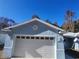 Close-up of the home's two-car garage and matching blue paint and modern design at 12882 Se 42Nd Ct, Belleview, FL 34420