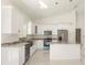 Modern kitchen with white cabinets, granite countertops, stainless steel appliances, and marble island at 12876 Se 42Nd Ct, Belleview, FL 34420