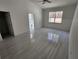 Bright main bedroom with grey tiled floor, white walls, ceiling fan and an open ensuite bathroom at 12876 Se 42Nd Ct, Belleview, FL 34420