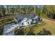 Aerial view showcasing home's modern design, long driveway, pristine lawn, and wooded surroundings at 13751 Sw 49Th Pl, Ocala, FL 34481