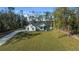 Aerial view showcasing the home's setting, long driveway, spacious front yard, and wooded surroundings at 13751 Sw 49Th Pl, Ocala, FL 34481