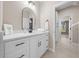 Bathroom featuring bright lighting, dual sinks, sleek faucet and white cabinets at 13751 Sw 49Th Pl, Ocala, FL 34481