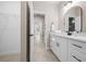 Bathroom featuring dual sinks, white cabinetry, matte black hardware and walk-in closet at 13751 Sw 49Th Pl, Ocala, FL 34481