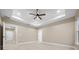 Bright bedroom features a tray ceiling, fan, and ample space, creating a comfortable environment at 13751 Sw 49Th Pl, Ocala, FL 34481