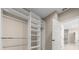 Large walk-in closet with custom shelving and access to a bathroom with shower at 13751 Sw 49Th Pl, Ocala, FL 34481