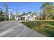 View of home and long driveway leading to a spacious garage, surrounded by a grassy lawn at 13751 Sw 49Th Pl, Ocala, FL 34481