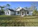 Exterior view of a modern farmhouse with manicured lawn and black trim details at 13751 Sw 49Th Pl, Ocala, FL 34481