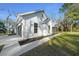 Bright, white exterior showing landscaped walkway and two-car garage on a sunny day at 13751 Sw 49Th Pl, Ocala, FL 34481