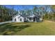 Well-maintained single-Gathering home on a grassy lawn, surrounded by trees and nature at 13751 Sw 49Th Pl, Ocala, FL 34481