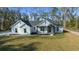 Stylish single-story home featuring crisp white exterior, dark gray roof, and lush green lawn at 13751 Sw 49Th Pl, Ocala, FL 34481