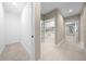Hallway with tile flooring leading to various rooms, showcasing the home's layout and natural light at 13751 Sw 49Th Pl, Ocala, FL 34481